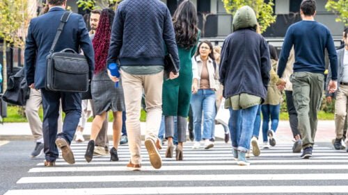 Pedestrians in Montgomery walking through a busy crosswalk.
