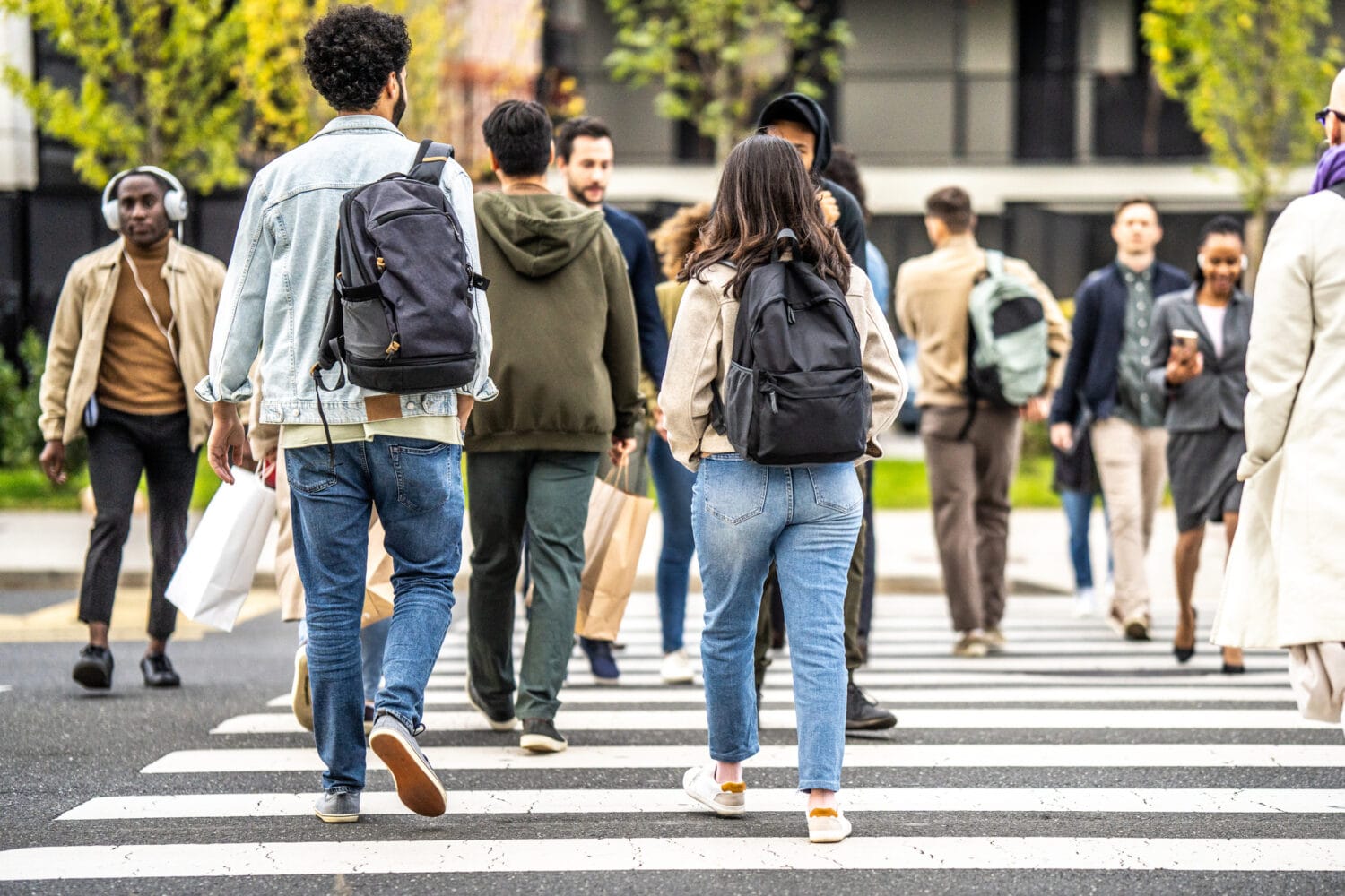 A diverse group of people crossing at a crosswalk.