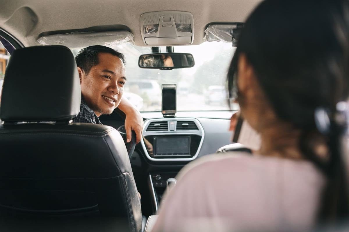 Tuskegee rideshare driver turns to greet passenger.