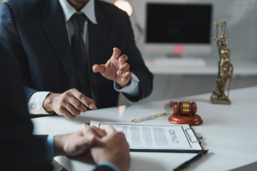 Alabama personal injury attorney gestures with hands while reviewing documents with client.